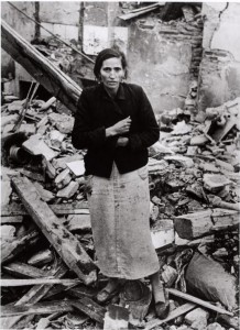 Robert Capa, [Woman standing amid rubble of buildings destroyed by Nationalist air raids, Madrid], Winter 1936/37. The Robert Capa and Cornell Capa Archive, International Center of Photography.