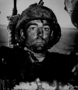 A Coast Guard assault transport comes this Marine after two days and nights of Hell on the beach of Eniwetok in the Marshall Islands. February 1944. US National Archives, Public Domain.